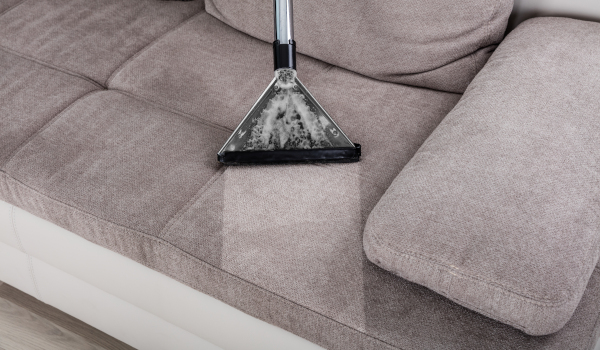 Closeup,Of,Woman,Cleaning,Sofa,With,Vacuum,Cleaner,At,Home